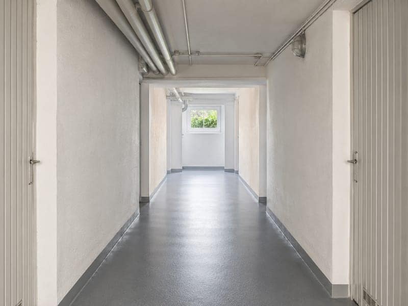 Frisch gewischter Kellergang mit Tageslicht aus einem Kellerfenster